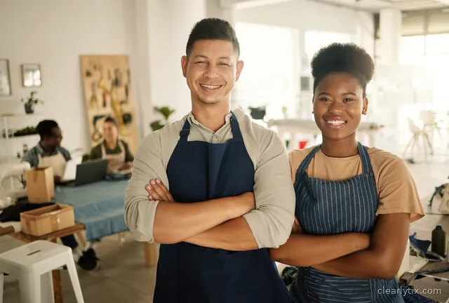 Two shop owners smiling confidently in their store.
