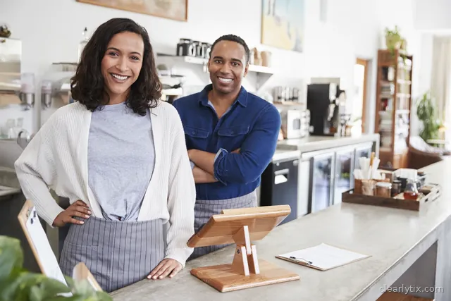 Smiling staff behind the counter of a small hospitality business.