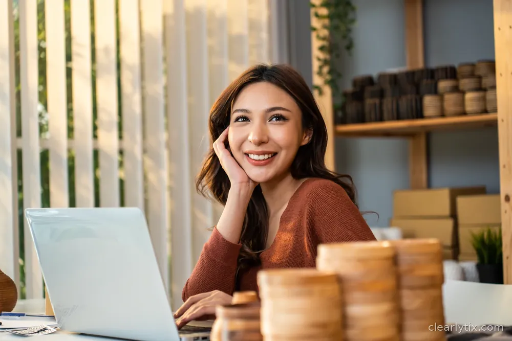 A website owner smiling at her laptop at home, reading her site report.