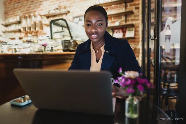 A freelancer working on her laptop in a coffee shop.